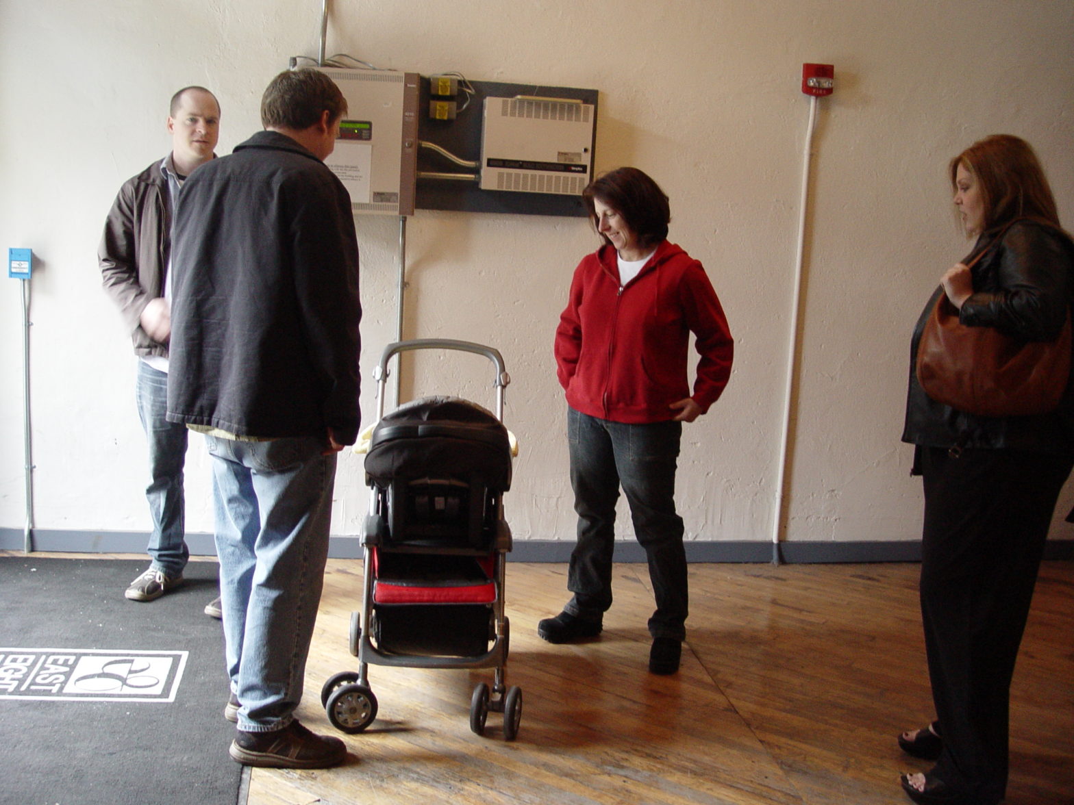 Folks stand around a baby in a stroller
